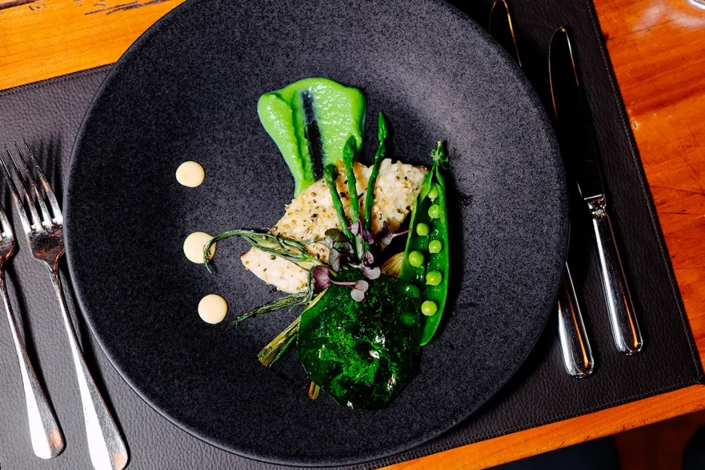 Photographie culinaire professionnelle par Speetch : plat de poisson gastronomique avec purée de petits pois et dressage soigné, service pour restaurants dans le Canton de Vaud et en Suisse romande.