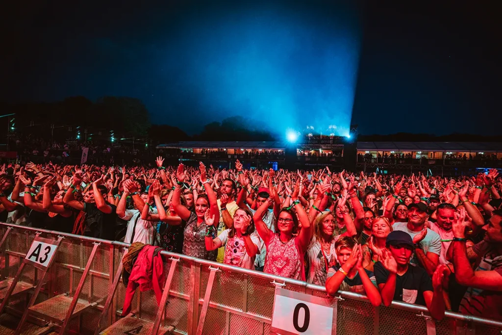 Photographie événementielle réalisée par Speetch au Venoge Festival dans le Canton de Vaud : vue du public enthousiaste lors d'un concert nocturne, reportage photo pour festivals et grands événements en Suisse romande.